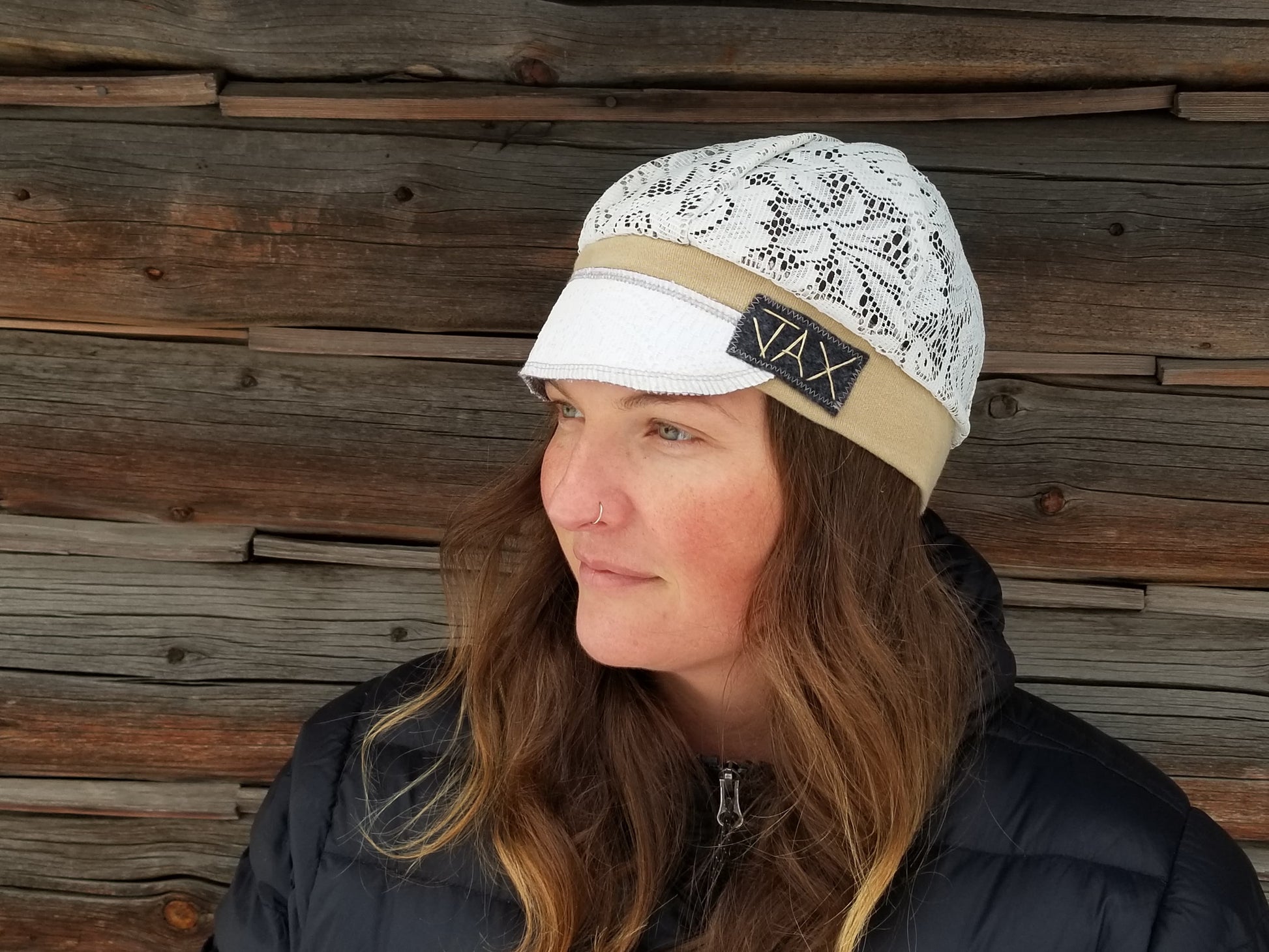 Lady with lace hat with decorative band against log cabin